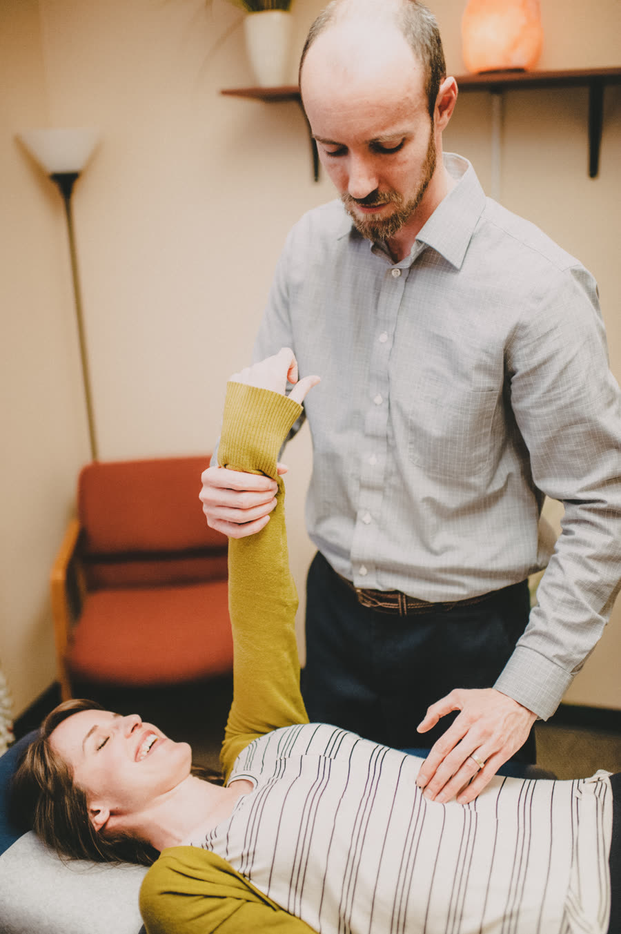 Dr. Andrew Rostenberg performing applied kinesiology arm-raise muscle testing on a patient at Red Mountain Clinic